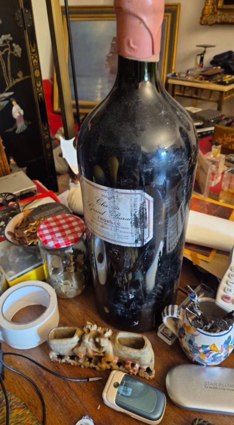 Grande bouteille ancienne de vin de Fronsac, Château Grand Barrail, poussiéreuse, entourée d'objets divers