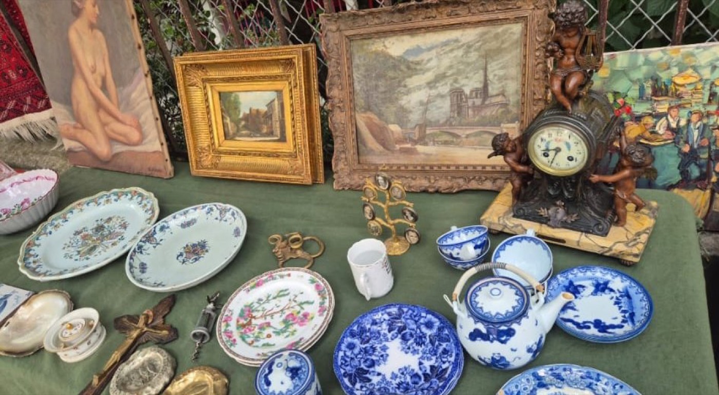 Table de brocante avec tableaux anciens encadrés, porcelaine bleu et blanc et pendule en bronze