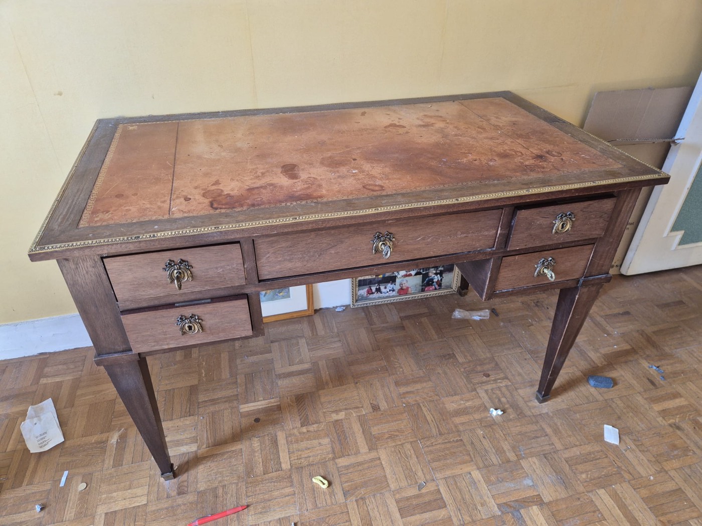 Bureau plat ancien de style Louis XVI, plateau gainé de cuir patiné et encadrement de bronze doré