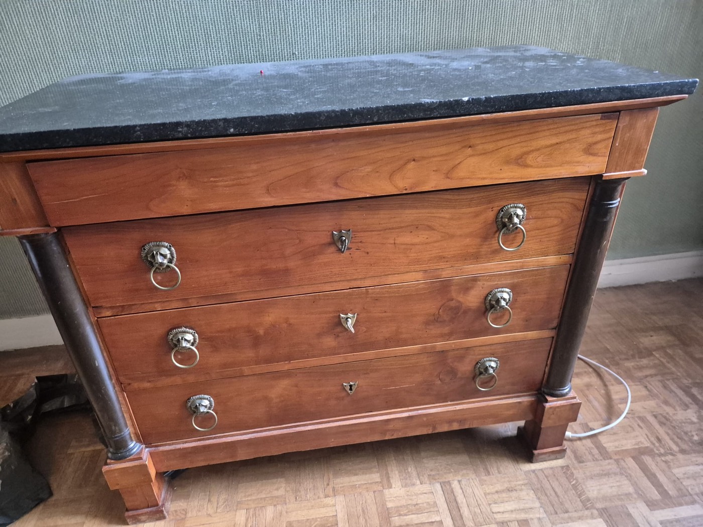 Commode ancienne d'époque Empire en merisier, dessus en marbre noir, poignées à têtes de lion et colonnes détachées