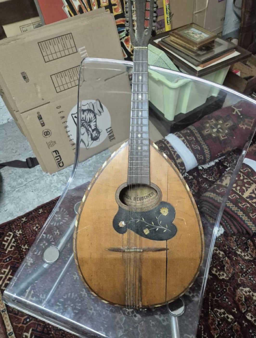 Mandoline ancienne en bois signée Paul Beuscher, table florale décorée, posée sur un tapis