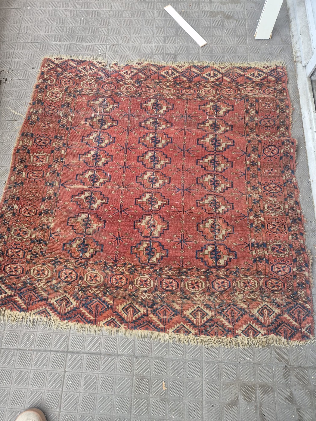 Tapis ancien d'Orient noué main de type Boukhara, fond rouge à motifs de güls géométriques, franges usées