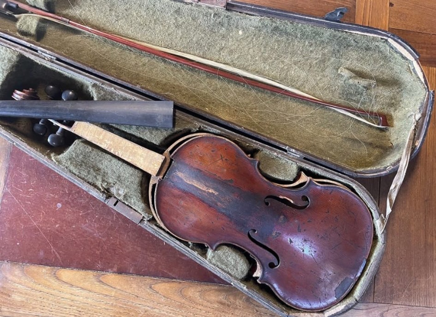 Violon ancien à la patine brune usée présenté avec son archet dans un étui d'origine